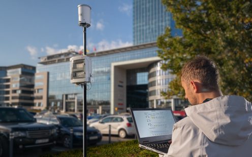 Smart Raineo meter installed on the street. Man is looking at the computer.